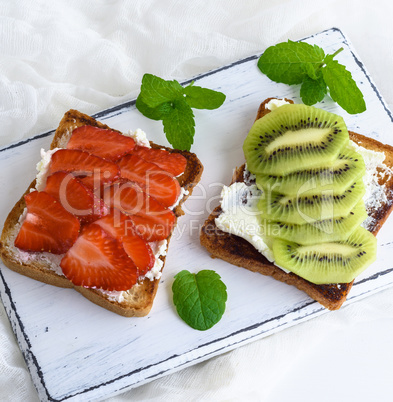 two toast with mild curd, slices of strawberry and kiwi