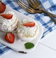 meringue cakes with cream and fresh strawberries