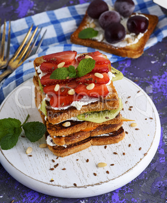 a pile of French toast with cottage cheese, strawberries, kiwi a