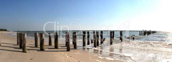 Clear blue sky over the old dilapidated pier on the beach
