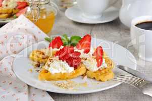 Belgian waffles with whipped cream and strawberries