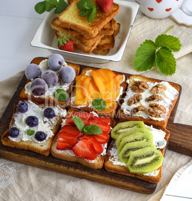 toasts with soft cheese, strawberries, kiwi, walnuts, cherries a