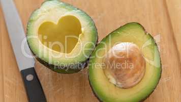 Fresh Cut Avocado With Heart Shaped Pit Area On Wooden Cutting B