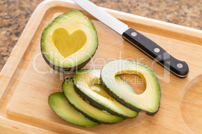 Fresh Cut Avocado With Heart Shaped Pit Area On Wooden Cutting B