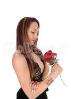 Beautiful woman looking at her red rose
