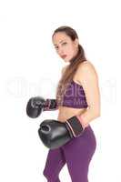 Serious looking woman with black boxing cloves