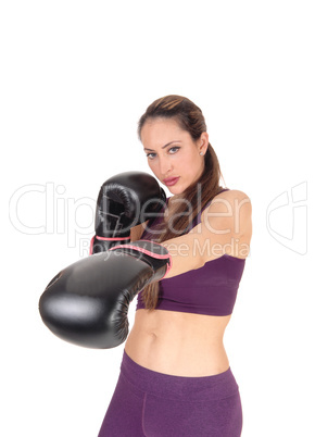 Slim woman punching with boxing cloves