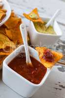 Chili sauce and nachos chips with guacamole sauce on background