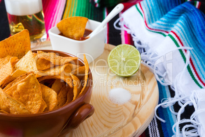 Close up of nachos chips sauce and beer