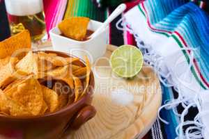 Close up of nachos chips sauce and beer