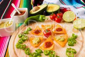 Nachos chips and vegetables on a chopping board