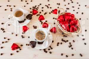 Red chocolate hearts in a small basket and two cups of coffee