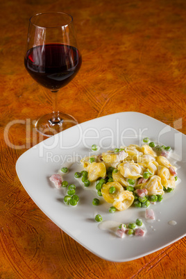 Tortellini with cream ham peas and red wine