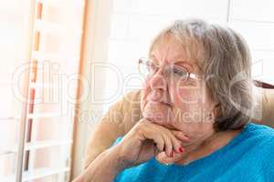 Contemplative Senior Woman Gazing Out of Her Window
