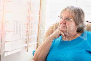 Contemplative Senior Woman Gazing Out of Her Window