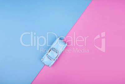 Travel blue car model on pink blue background. Top view