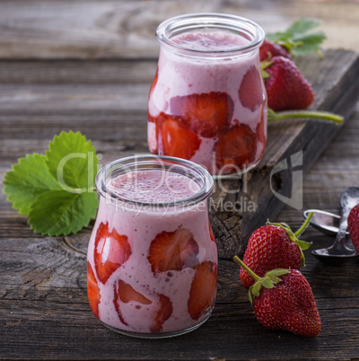 yogurt with fresh red strawberries in a glass jar