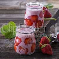 yogurt with fresh red strawberries in a glass jar