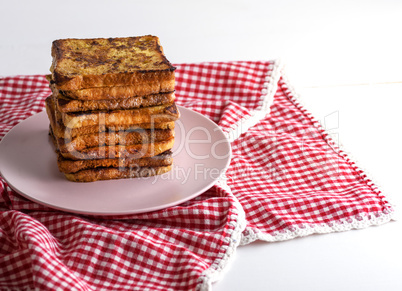 fried French toast on a ceramic pink plate