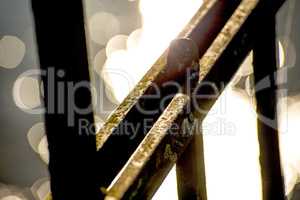 old railing in a port with backlit reflexions of the sea