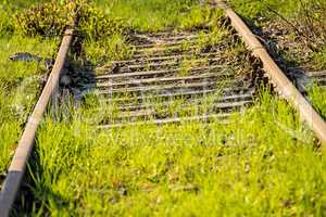 rails out of order overgrown with green grass