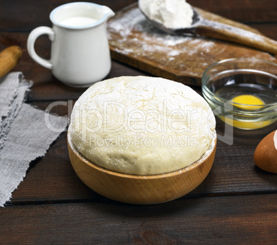 dough made from white wheat flour in a wooden bowl