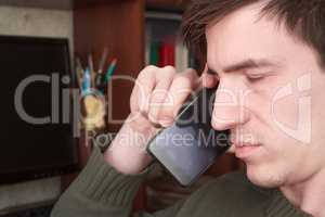 a young guy talking on black, shut his eyes