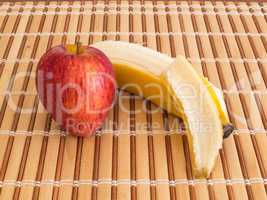 Side view of apple and peeled banana.