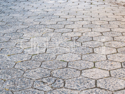 Street of hexagonal concrete blocks, badly preserved.
