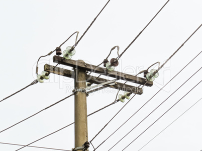 Post with electric transmission wires on white background