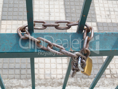 Blue grille with used and dirty padlock and chain.