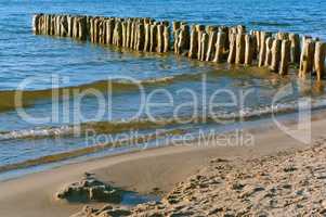 the groynes in the sea, a breakwater made of wood, sea waves protection from