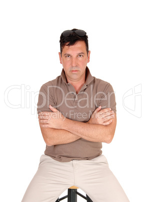 Serious looking man sitting arms crossed