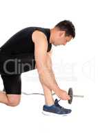 Exercising man tying his shoe laces