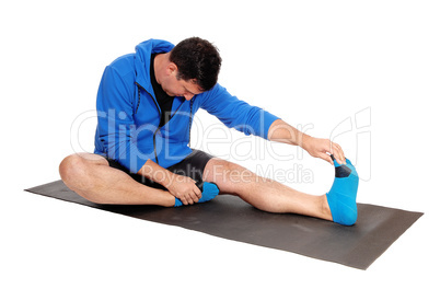 Man sitting on floor stretching his body