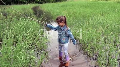 A girl in rubber boots on a swamp