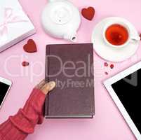 female human hand holds a book in a brown cover