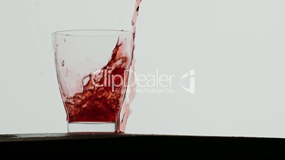 Red berry juice poured in glass