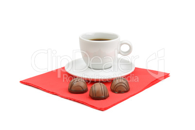A cup of coffee and chocolate candies isolated on white backgrou