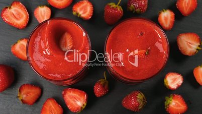 Strawberry falling in fresh smoothie in slow motion