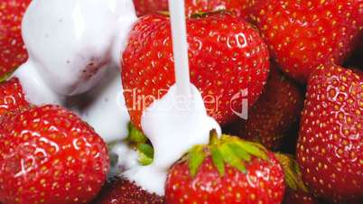 Yogurt flowing on fresh strawberries