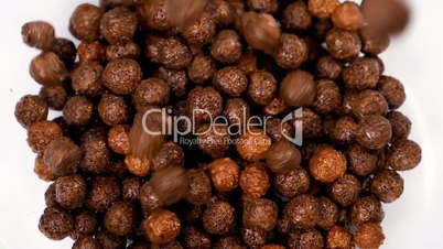 Chocolate cereals falling in glass bowl