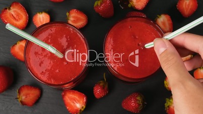 Fresh strawberry smoothie flowing in glasses ready to drink