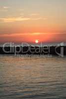 Orange and red sun over a jetty at Doctors Pass river near Lowde