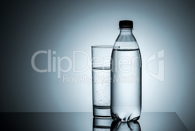 Plastic bottle and glass with water