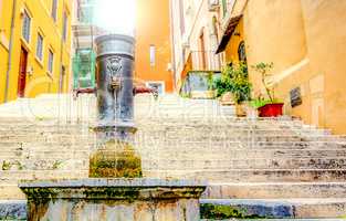 old cast iron fountain in front of an ancient staircase in Rome