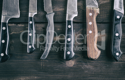 various knives on a brown wooden board