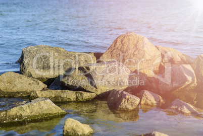 Large stones in sea water on a summer day