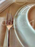 Fork, plate and napkin on linen towel.