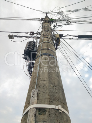 Cement pole with many electric wires.